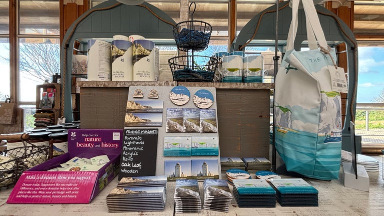 Image of a table with lots of different White Cliffs of Dover souvenirs and windows with trees in the background